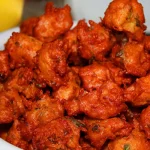 Crispy and spicy Gobi 65 garnished with curry leaves and served hot as a starter.